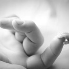 premature baby holding mums finger