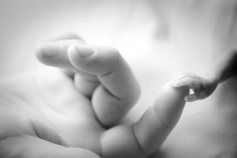 premature baby holding mums finger