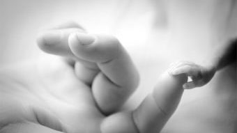 premature baby holding mums finger