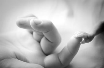 premature baby holding mums finger