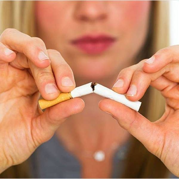 woman breaking cigarette in half