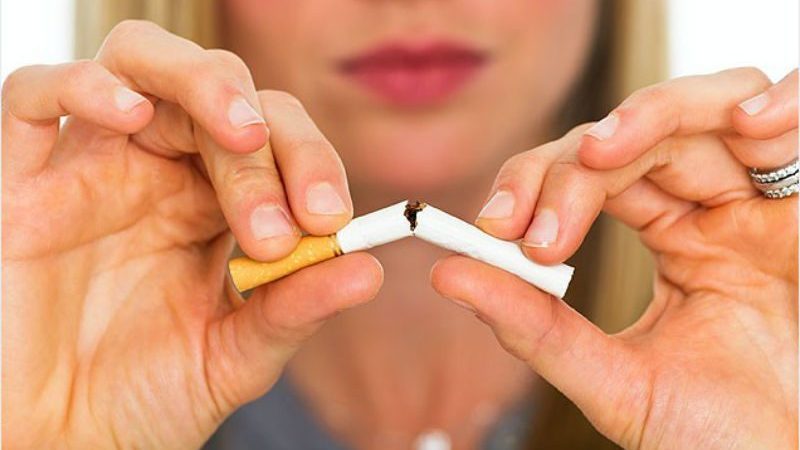 woman breaking cigarette in half