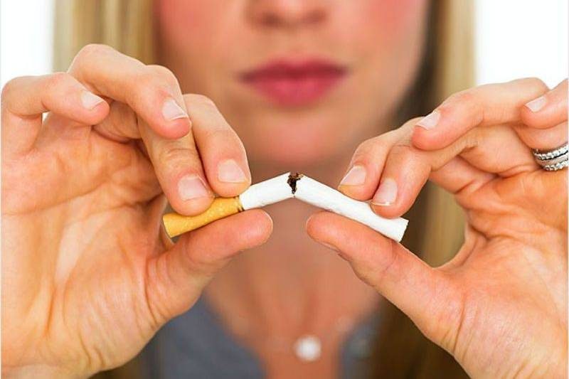 woman breaking cigarette in half