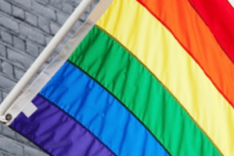 raibow flag infront of grey brick wall