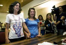 Helena Paixao, right, and Teresa Pires, left, hold hands while getting married at a civil registry office on Monday, June 7, 2010 in Lisbon.