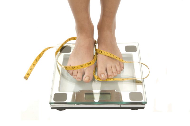 person standing barefoot on glass scale 