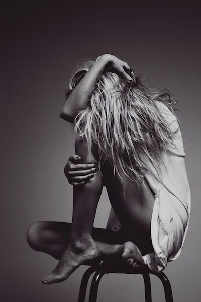 black and white photo of woman sitting on chair being upset